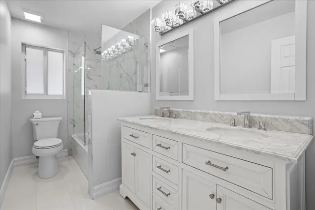 a bathroom with a granite countertop sink a toilet and a mirror