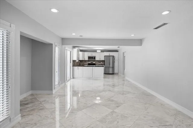a view of a kitchen with a sink and a refrigerator
