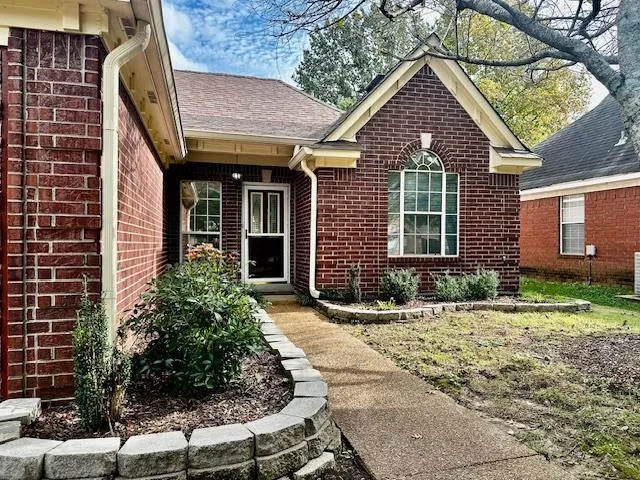 a view of brick house with yard and plants