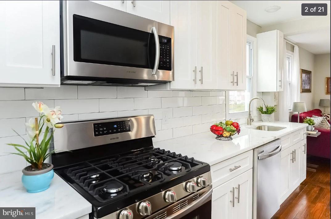 112 Upland Road Brookhaven, PA 19015 - Photo 2 of 21 a kitchen with a stove a microwave and cabinets