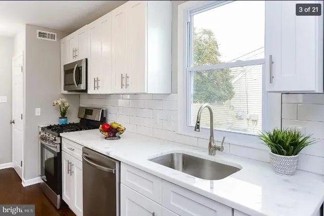 a kitchen with stainless steel appliances a sink a microwave and window