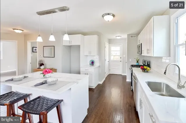 a kitchen with a sink and wooden floor
