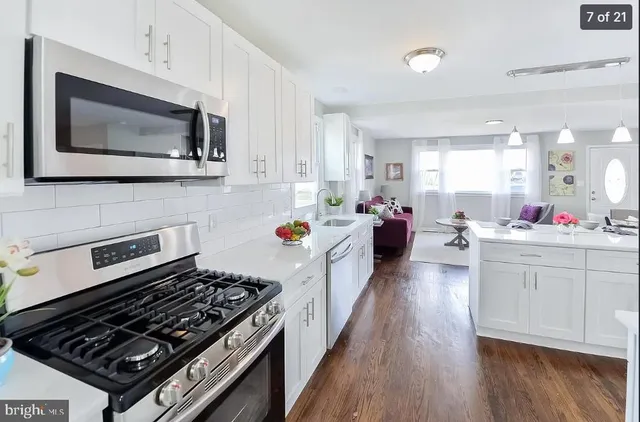 a kitchen with microwave a stove and cabinets