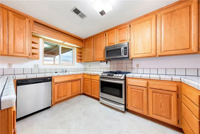 a kitchen with stainless steel appliances granite countertop a sink stove and microwave