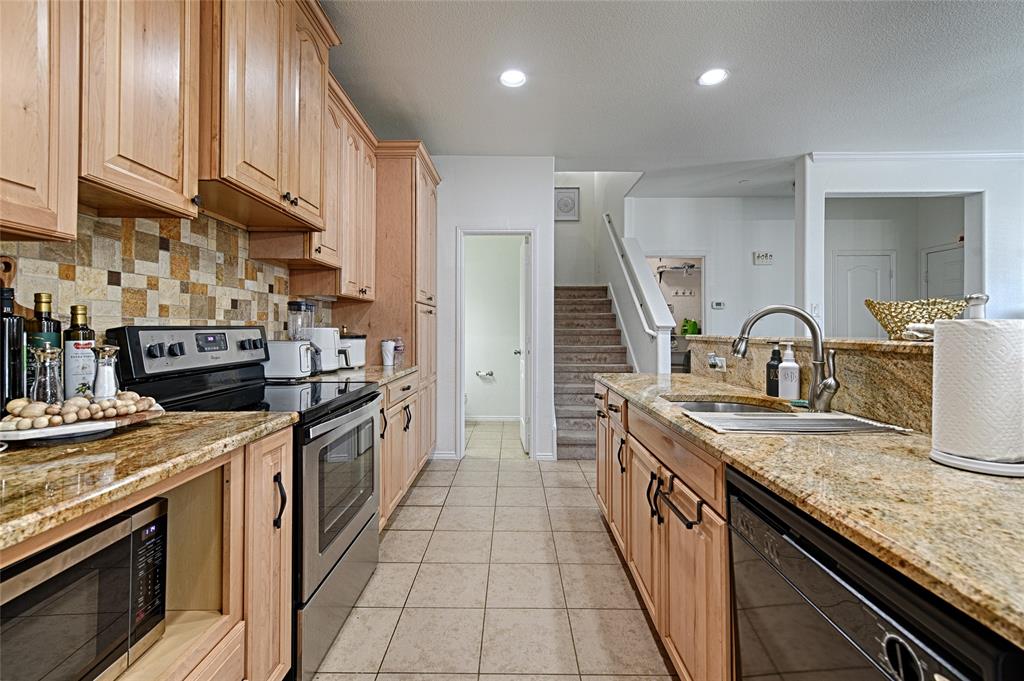 5984 Stone Mountain Road The Colony, TX 75056 - Photo 15 of 25 a large kitchen with stainless steel appliances granite countertop a stove a sink and a refrigerator