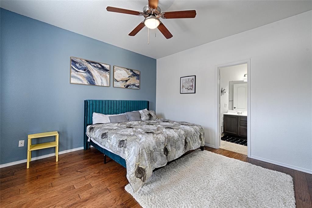 5984 Stone Mountain Road The Colony, TX 75056 - Photo 19 of 25 a bedroom with a bed and a chandelier