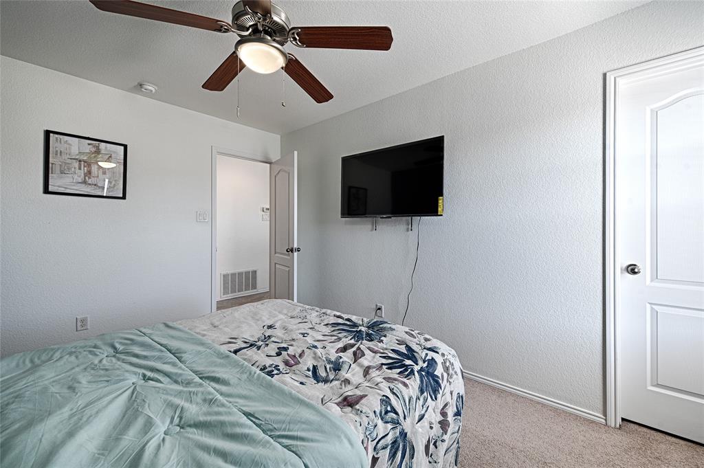 5984 Stone Mountain Road The Colony, TX 75056 - Photo 24 of 25 a bedroom with a bed and a flat screen tv