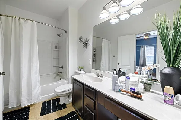 a bathroom with double vanity sinks a toilet a mirror and shower