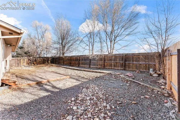 a view of backyard with wooden fence