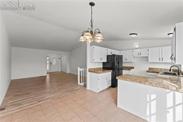 a kitchen with stainless steel appliances granite countertop a sink dishwasher and white cabinets with wooden floor