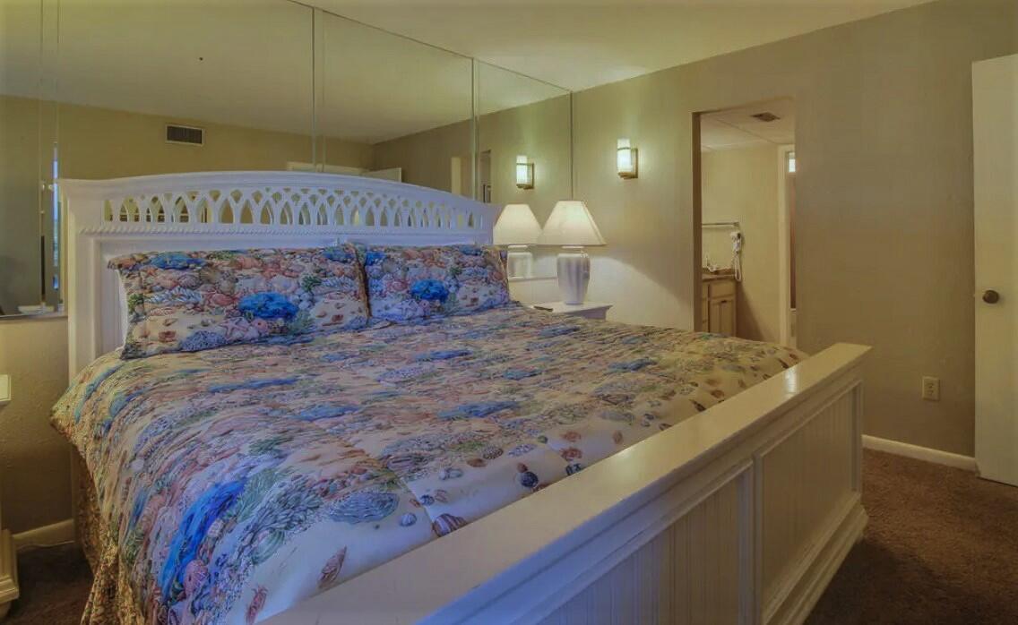 11483 Front Beach Road, Unit 307 Panama City Beach, FL 32407 - Photo 9 of 12 a bedroom with a bed and a mirror