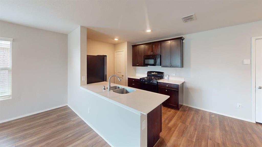 331 Buckeye Avenue Princeton, TX 75407 - Photo 5 of 22 a kitchen with a sink and a microwave