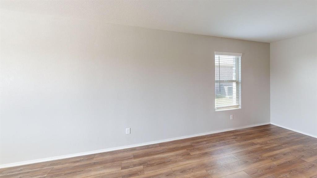 331 Buckeye Avenue Princeton, TX 75407 - Photo 8 of 22 an empty room with wooden floor and windows