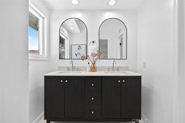 a bathroom with double vanity sinks and a mirror