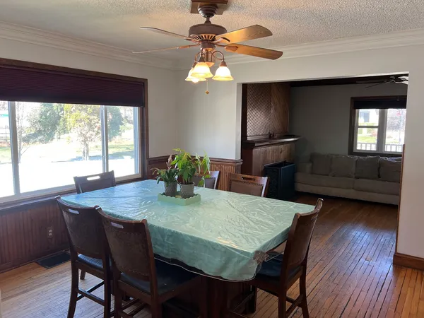a dining room with furniture a window and wooden floor