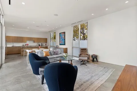 a living room with furniture kitchen view and a window