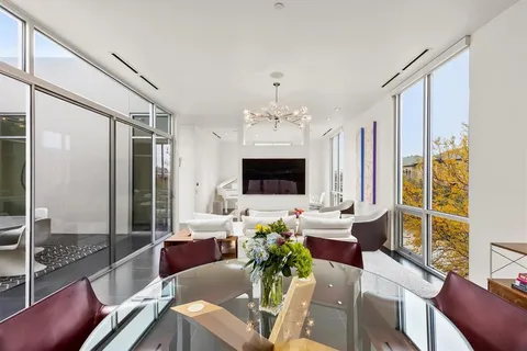a living room with stainless steel appliances furniture a rug and a kitchen view
