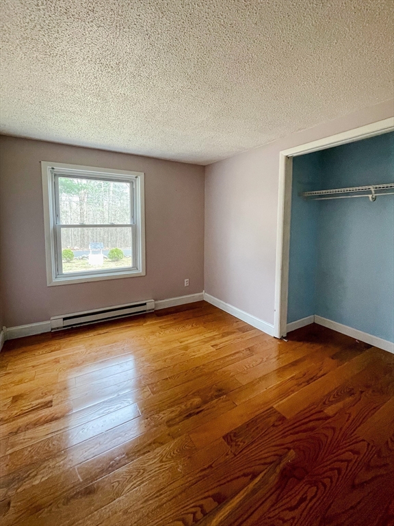 836 Bemis Road Warren, MA 01585 - Photo 13 of 24 an empty room with wooden floor and windows