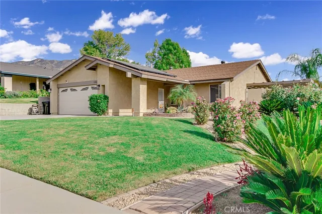 a front view of a house with a garden and yard