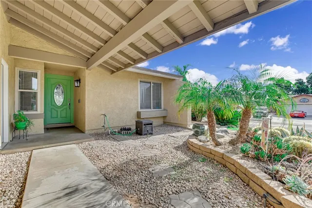 a backyard of a house with potted plants and large tree