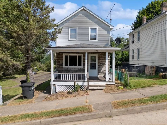 a view of a house with a yard and fence