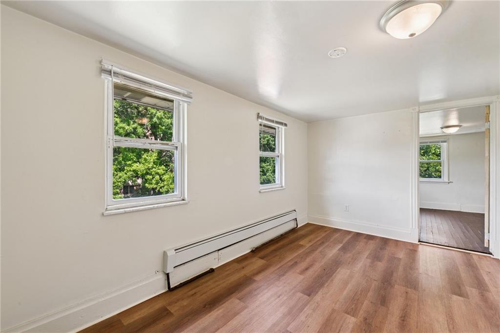 220 Oneida Street Monessen, PA 15062 - Photo 21 of 28 an empty room with wooden floor and windows