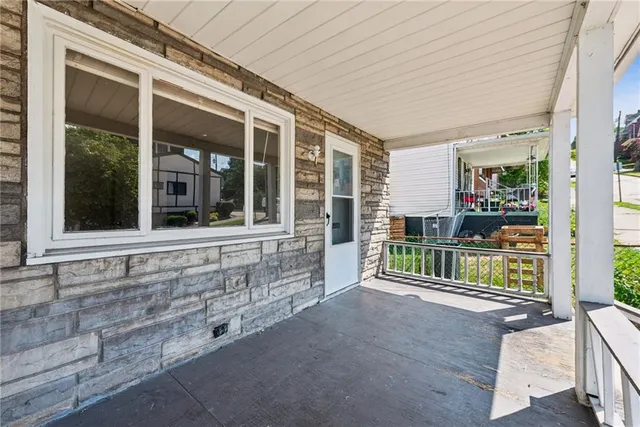 a view of a house with porch and wooden fence