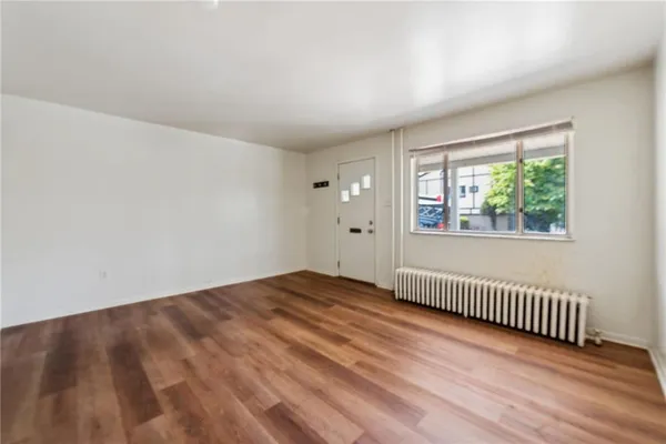 a view of empty room with wooden floor