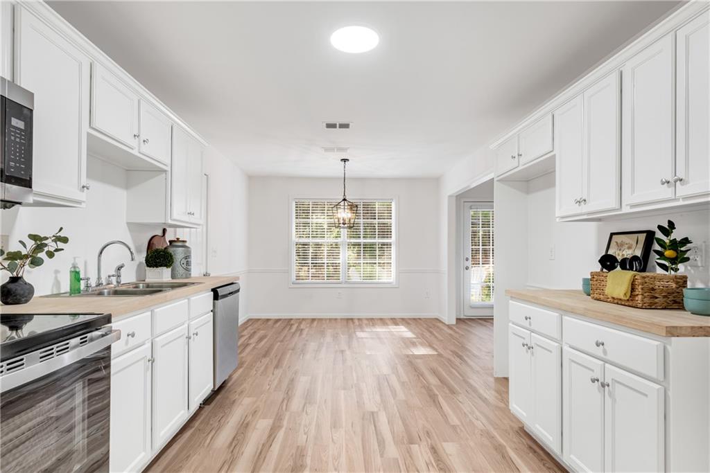 125 Pine Ridge Trace Athens, GA 30605 - Photo 2 of 28 a kitchen with a sink wooden floor and white cabinets