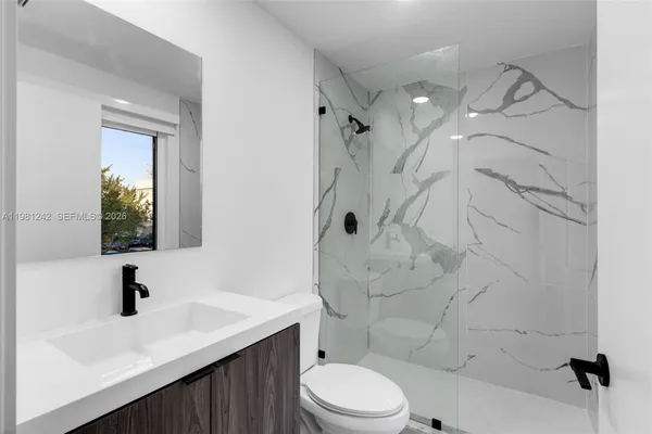 a bathroom with a sink toilet a mirror and shower