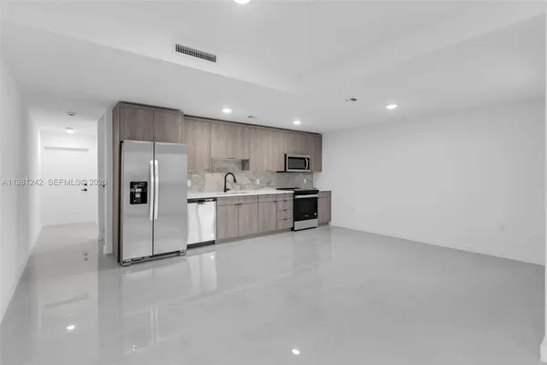 a large kitchen with cabinets and stainless steel appliances