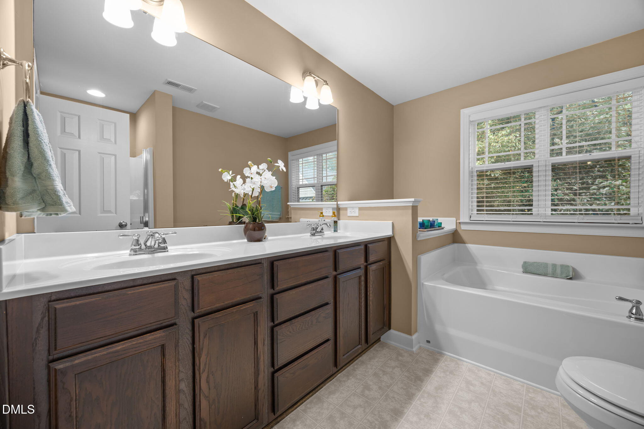 1929 Fieldhouse Avenue Raleigh, NC 27603 - Photo 14 of 29 a bathroom with a tub a sink double vanity and a mirror