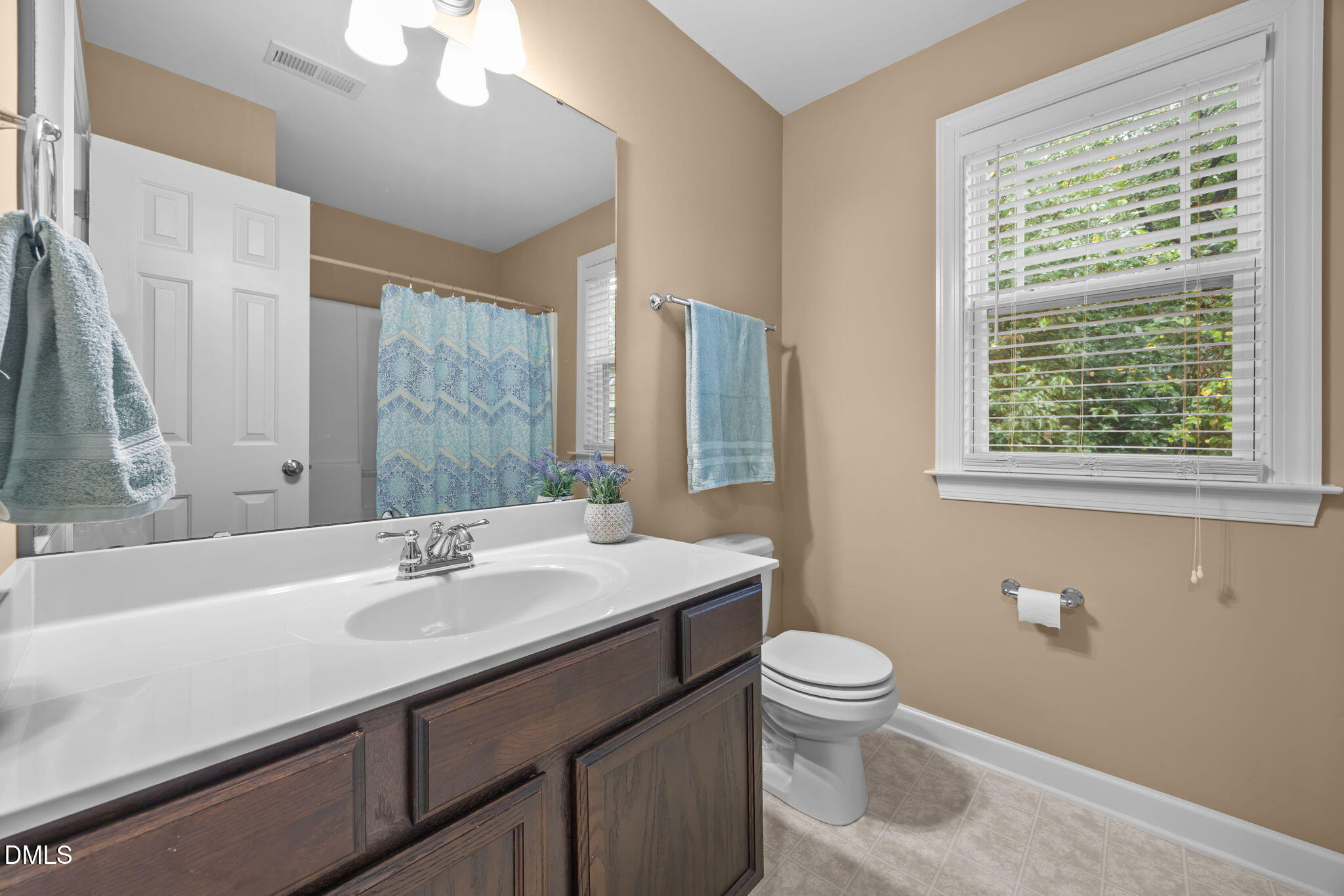 1929 Fieldhouse Avenue Raleigh, NC 27603 - Photo 18 of 29 a bathroom with a sink a toilet a mirror and a window