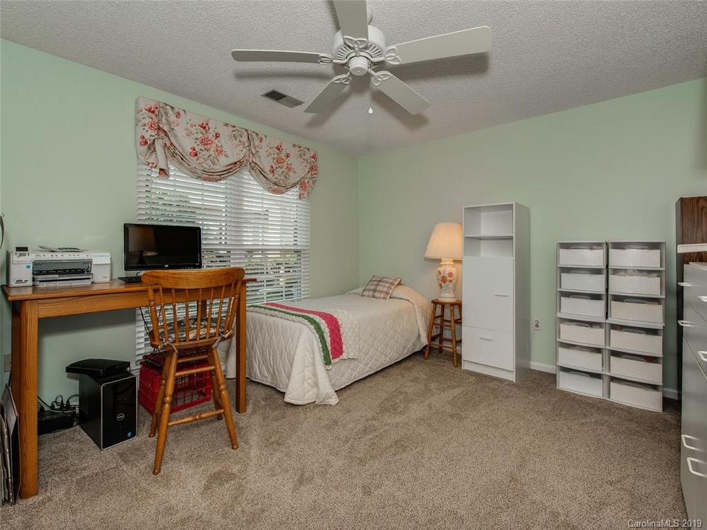 5009 Sharon Road Charlotte, NC 28210 - Photo 12 of 16 a bedroom with a bed and a flat tv screen on the dresser