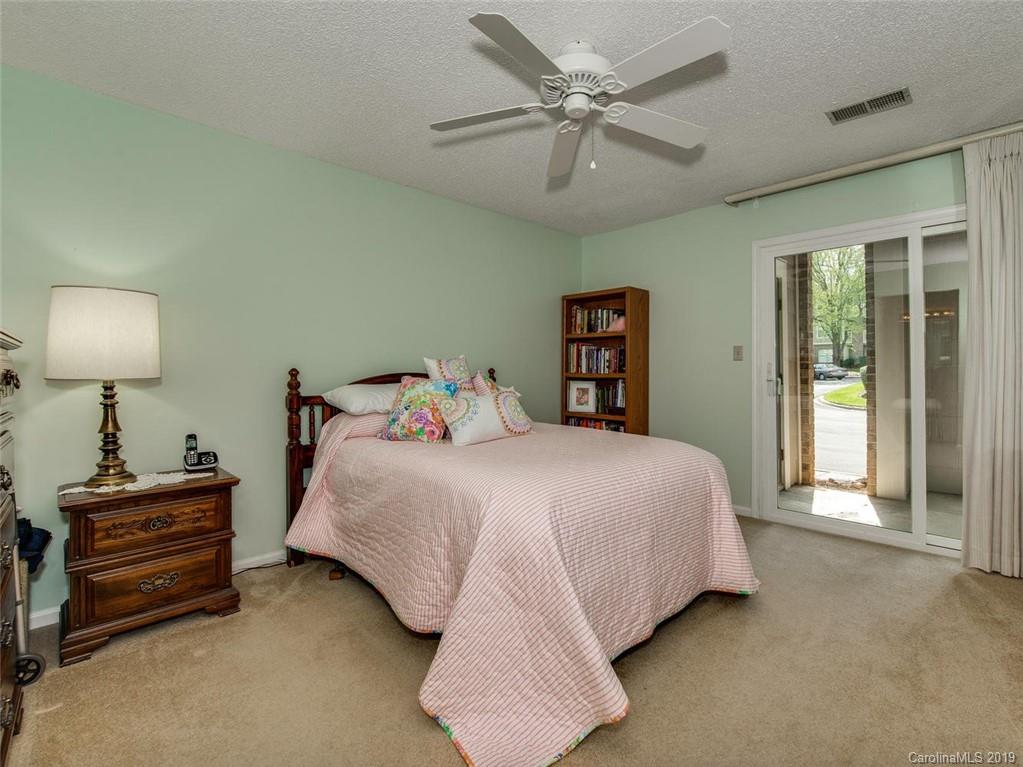 5009 Sharon Road Charlotte, NC 28210 - Photo 10 of 16 a bedroom with a bed and a chandelier