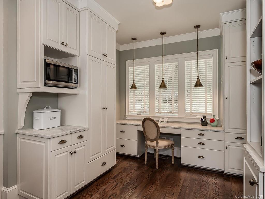 1114 Andover Road Charlotte, NC 28211 - Photo 14 of 44 a kitchen with stainless steel appliances white cabinets sink and wooden floor