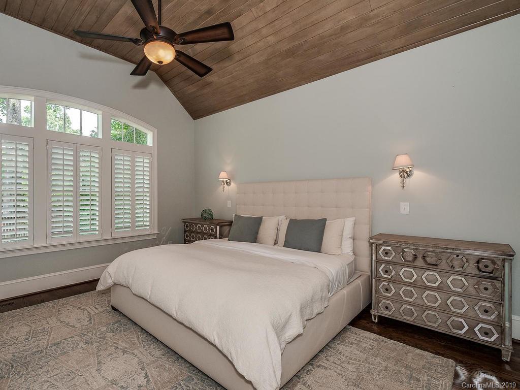 1114 Andover Road Charlotte, NC 28211 - Photo 19 of 44 a bedroom with a large bed and a chandelier