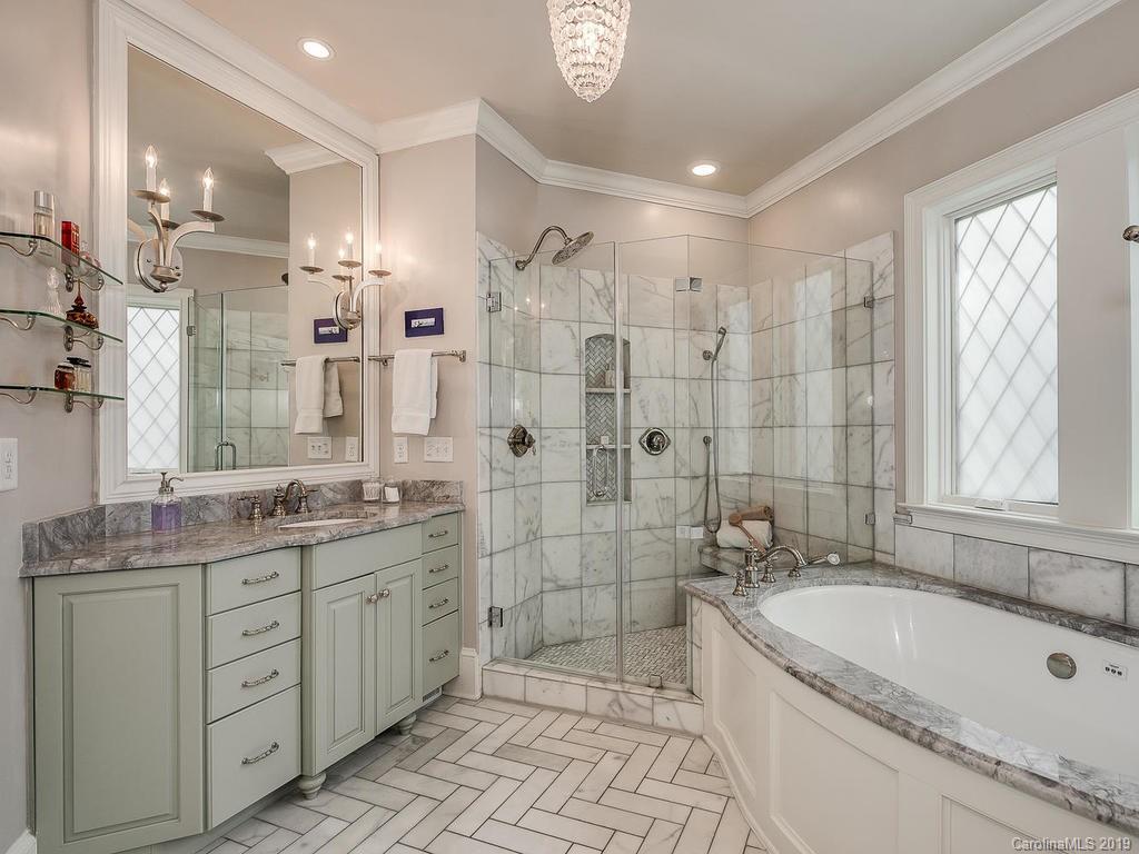 1114 Andover Road Charlotte, NC 28211 - Photo 22 of 44 a bathroom with a granite countertop sink a large mirror a shower and a bathtub
