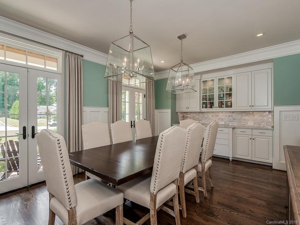 1114 Andover Road Charlotte, NC 28211 - Photo 5 of 44 a dining room with wooden floor a chandelier a wooden table and chairs