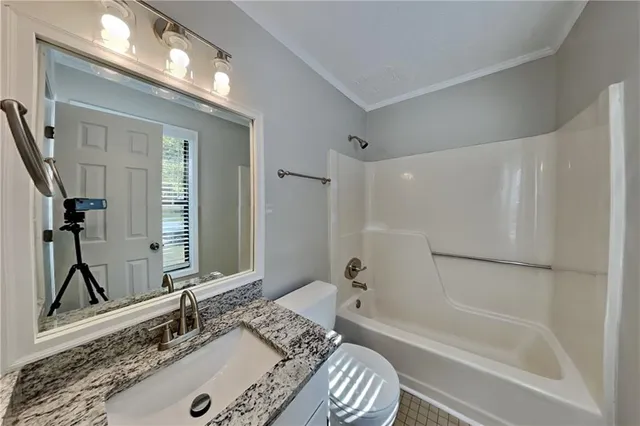 a bathroom with a granite countertop sink mirror and a bathtub