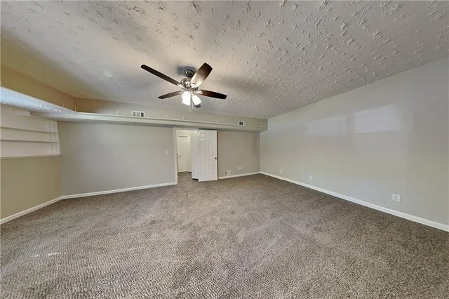 an empty room with a ceiling fan and window