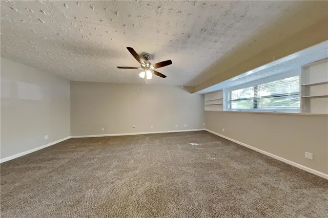 an empty room with a window and a fan