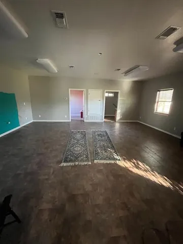 a view of an empty room with window and fireplace