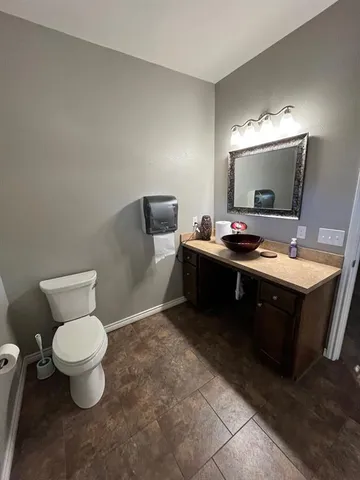 a spacious bathroom with a toilet sink and mirror