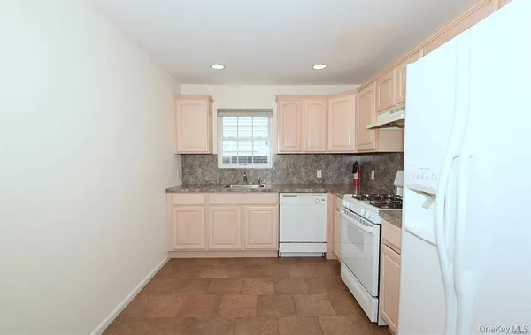 a kitchen with white cabinets stainless steel appliances and sink