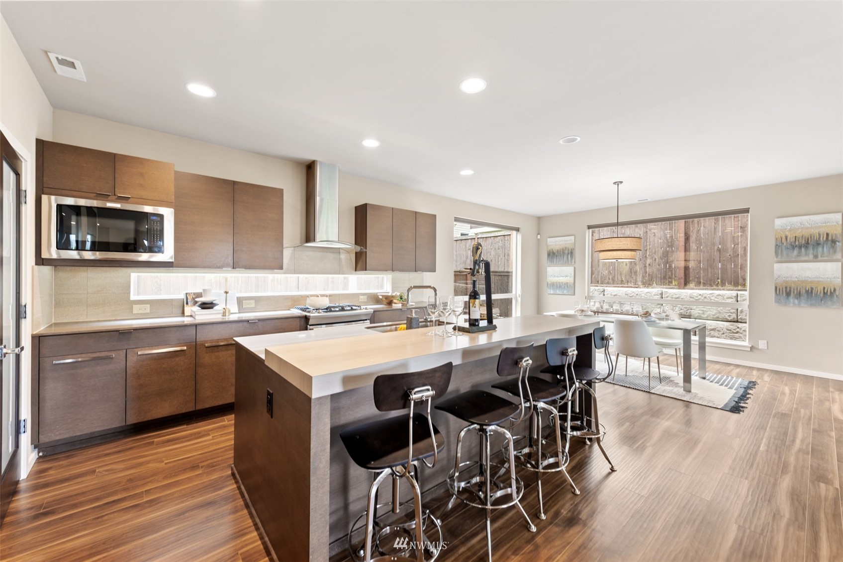 17007 40th Avenue Southeast Bothell, WA 98012 - Photo 6 of 26 a kitchen with stainless steel appliances granite countertop a stove top oven a sink dishwasher a dining table and chairs with wooden floor