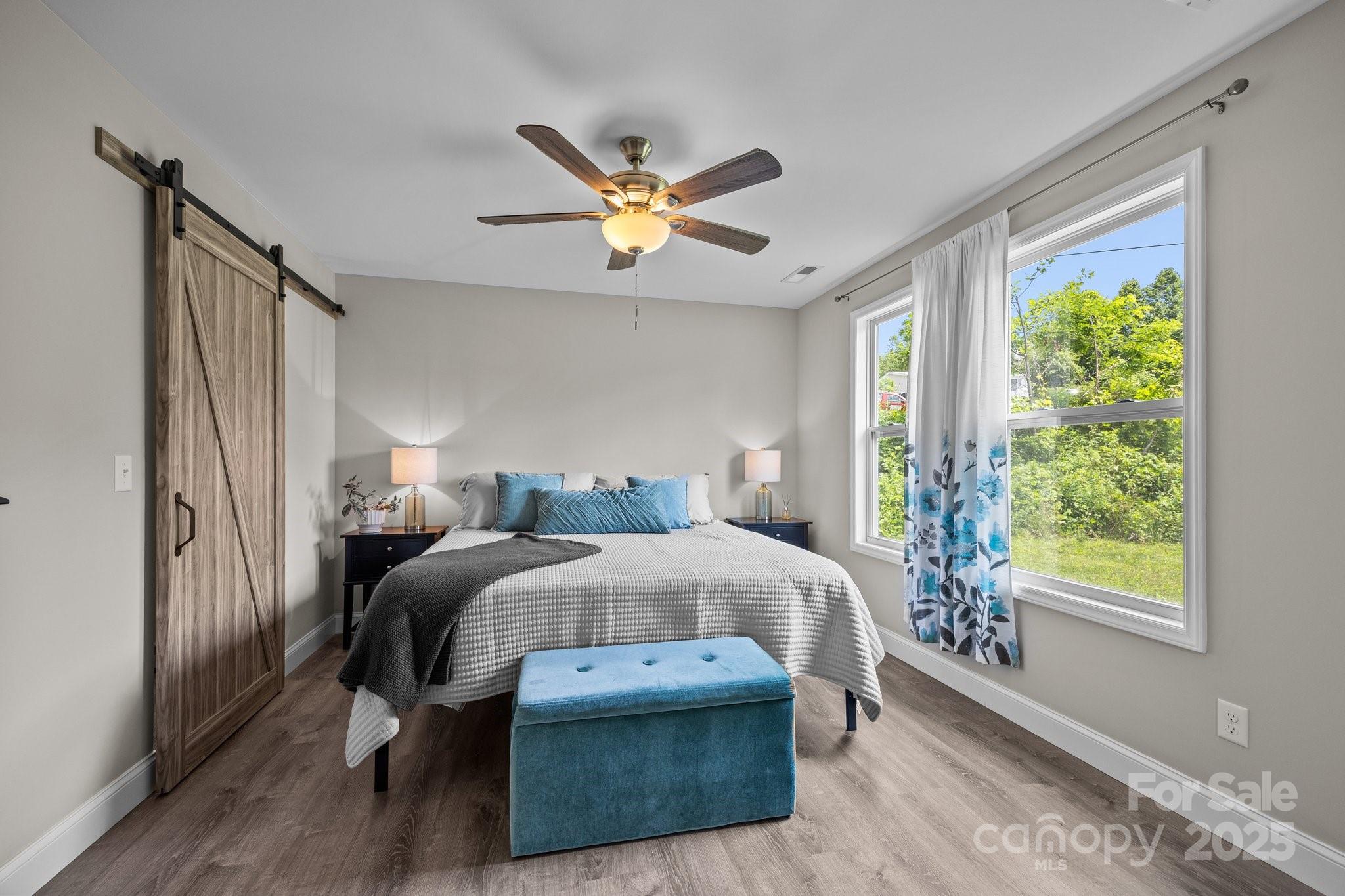 458 Summer Road Hendersonville, NC 28792 - Photo 17 of 29 a bedroom with a bed a ceiling fan and a large window