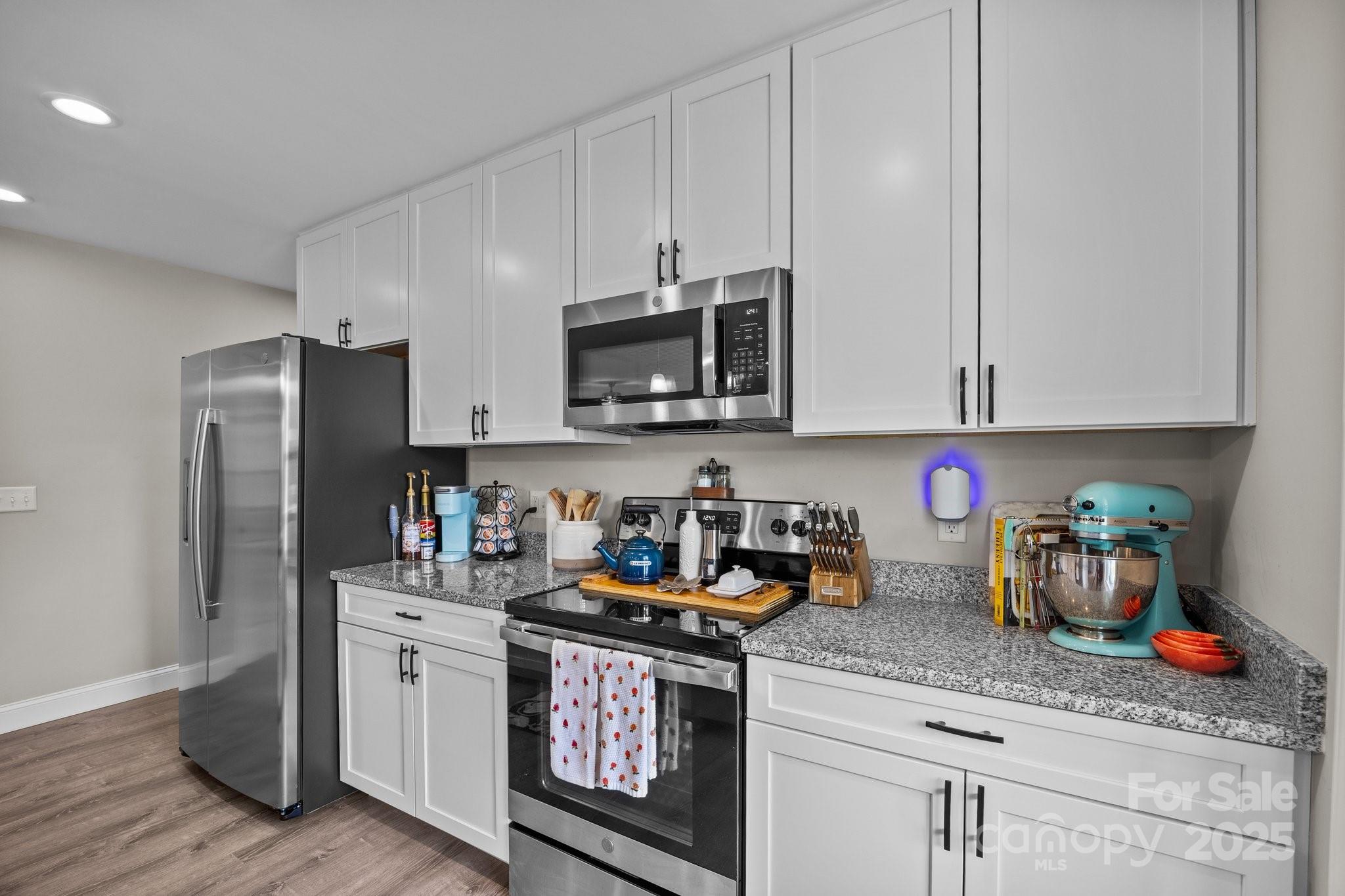 458 Summer Road Hendersonville, NC 28792 - Photo 9 of 29 a kitchen with stainless steel appliances granite countertop a refrigerator stove top oven a sink and dishwasher with wooden floor