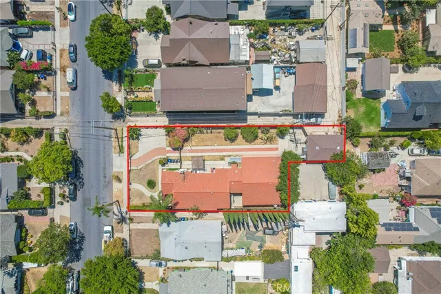 an aerial view of residential houses with outdoor space and parking