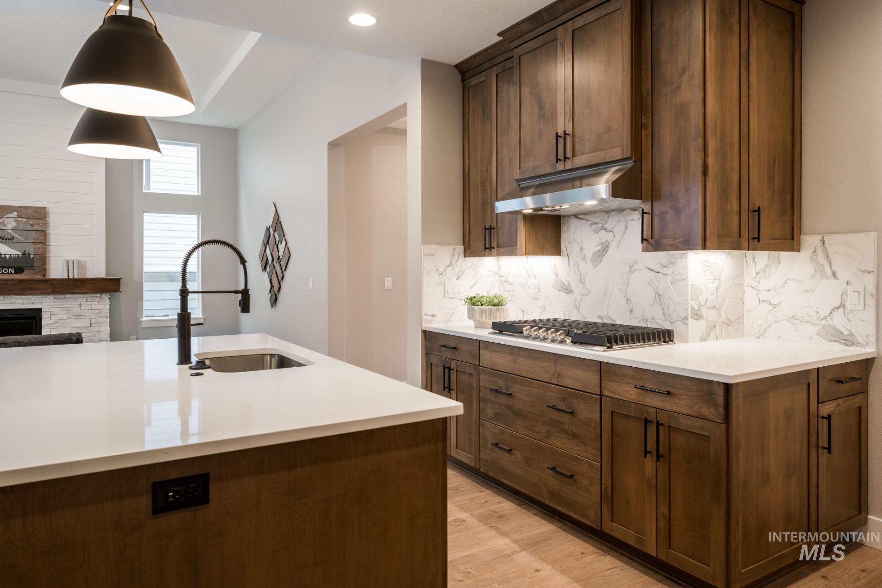 1279 West Malbar Street Meridian, ID 83646 - Photo 11 of 23 Kitchen with light wood-style flooring, light countertops, and ventilation hood
